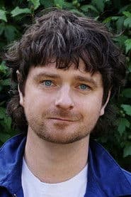 Michael Shanks as 10,000 Sandals Director