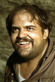 Ricardo Palacios as Don Carmelo, the priest